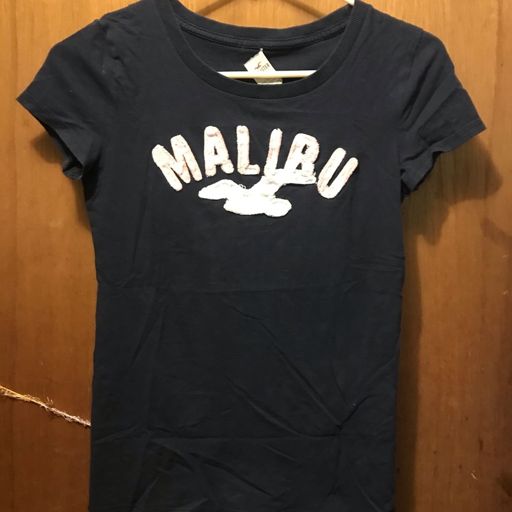 navy blue shirt Light pink letters. White seagull
